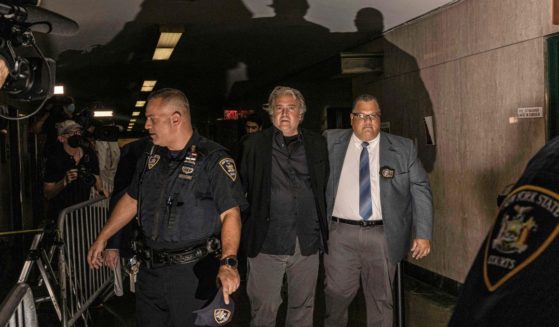 Steve Bannon, center, is led away from a New York court in handcuffs on Thursday.