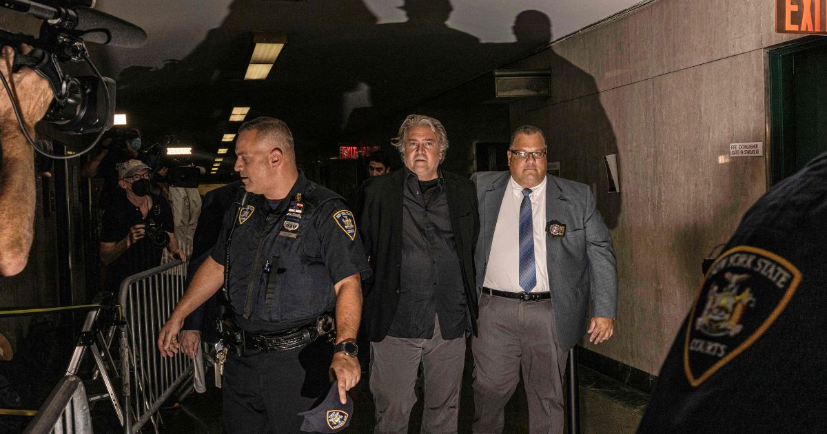 Steve Bannon, center, is led away from a New York court in handcuffs on Thursday.