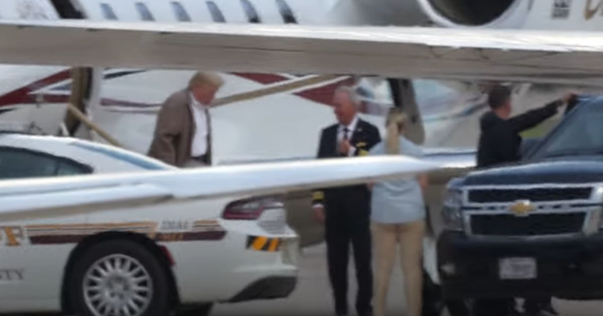 Former President Donald Trump walks onto the tarmac at Dulles Airport in Virginia on Sunday.