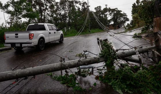 Downed power lines obstruct a road in Puerto Rico on Monday as the island suffers a massive power outage in the wake of Hurricane Fiona, which made landfall Sunday.