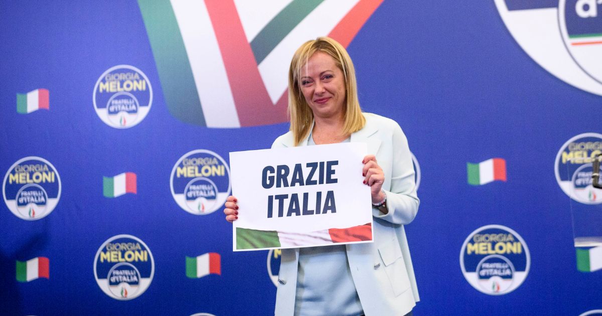 Giorgia Meloni, leader of the Fratelli d'Italia (Brothers of Italy) holds a "Thank You Italy" sign during a news conference at the party electoral headquarters overnight after Sunday's parliamentary elections.