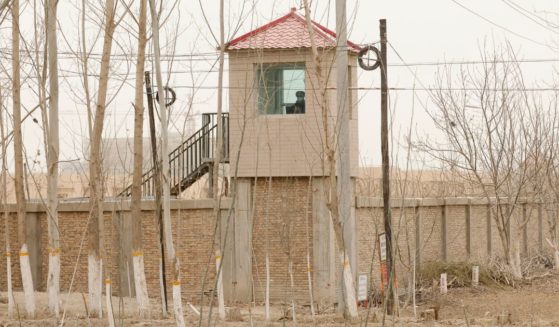 A Chinese guard sits in a watch tower outside of a Uyghur detention facility in Yarkent County, China, on March 21, 2021.