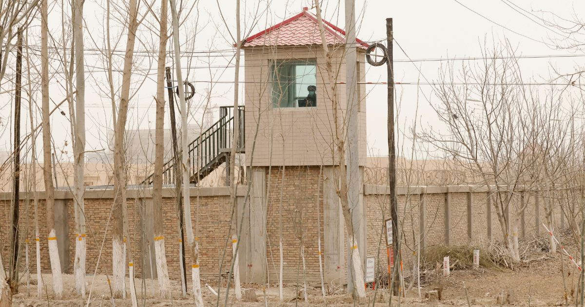 A Chinese guard sits in a watch tower outside of a Uyghur detention facility in Yarkent County, China, on March 21, 2021.