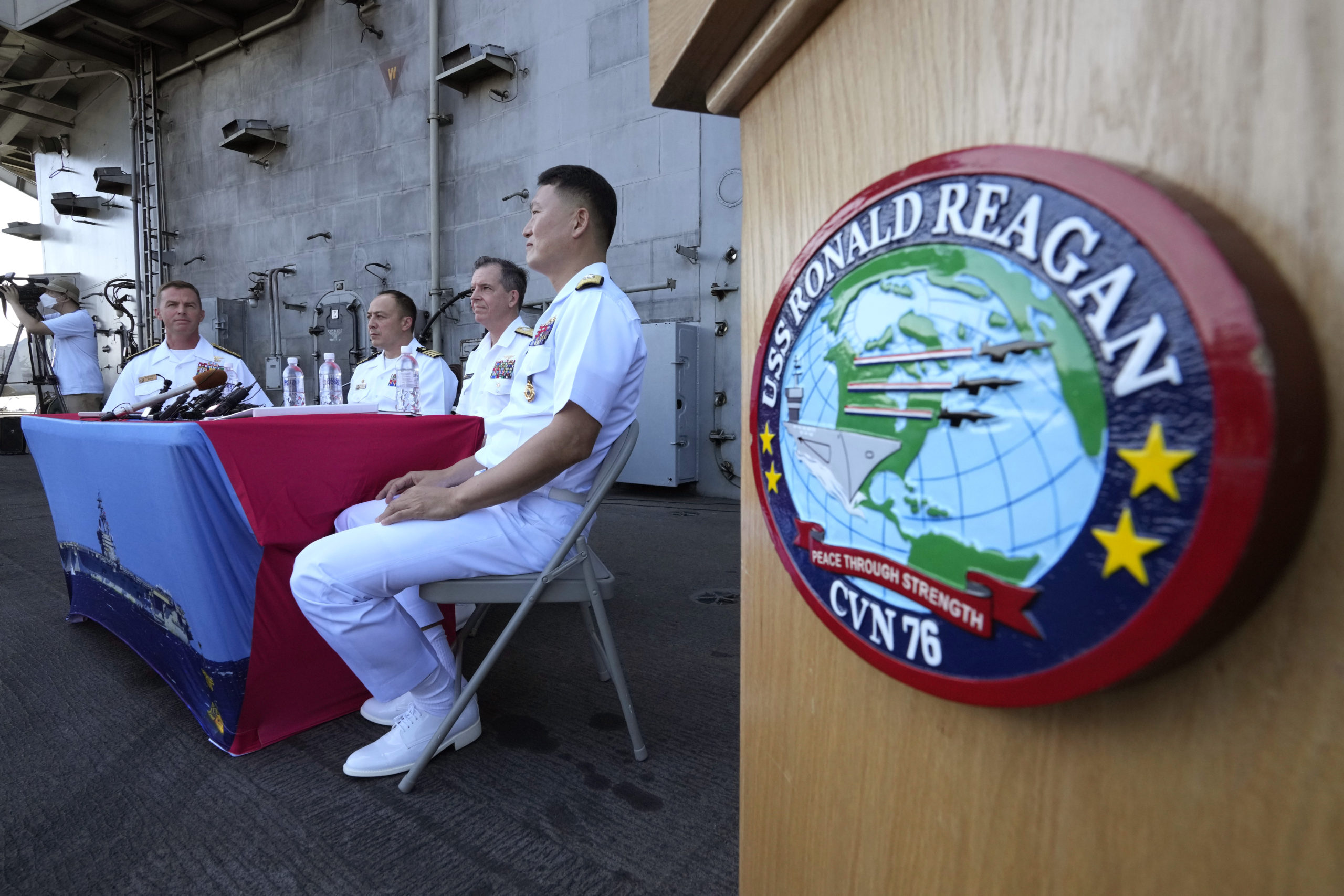 Rear Adm. Michael Donnelly, commander of the carrier strike group, second from right, listens to a reporter's question during a news conference on the deck of the nuclear-powered aircraft carrier USS Ronald Reagan in Busan, South Korea.