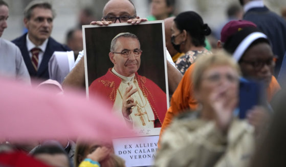 A man holds up a photograph of Pope John Paul I during his beatification ceremony in St. Peter's Square at the Vatican on Sunday.