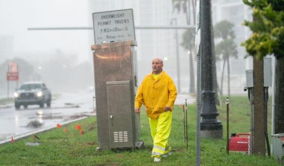 An emergency worker works deploys a generator to power a traffic signal as Hurricane Ian approaches on September 28, 2022 in Sarasota, Florida. Ian made landfall this afternoon, packing 150-mile-per-hour winds and a 12-foot storm surge and knocking out power to nearly 1.5 million customers, according to published reports. (Photo by Sean Rayford/Getty Images)