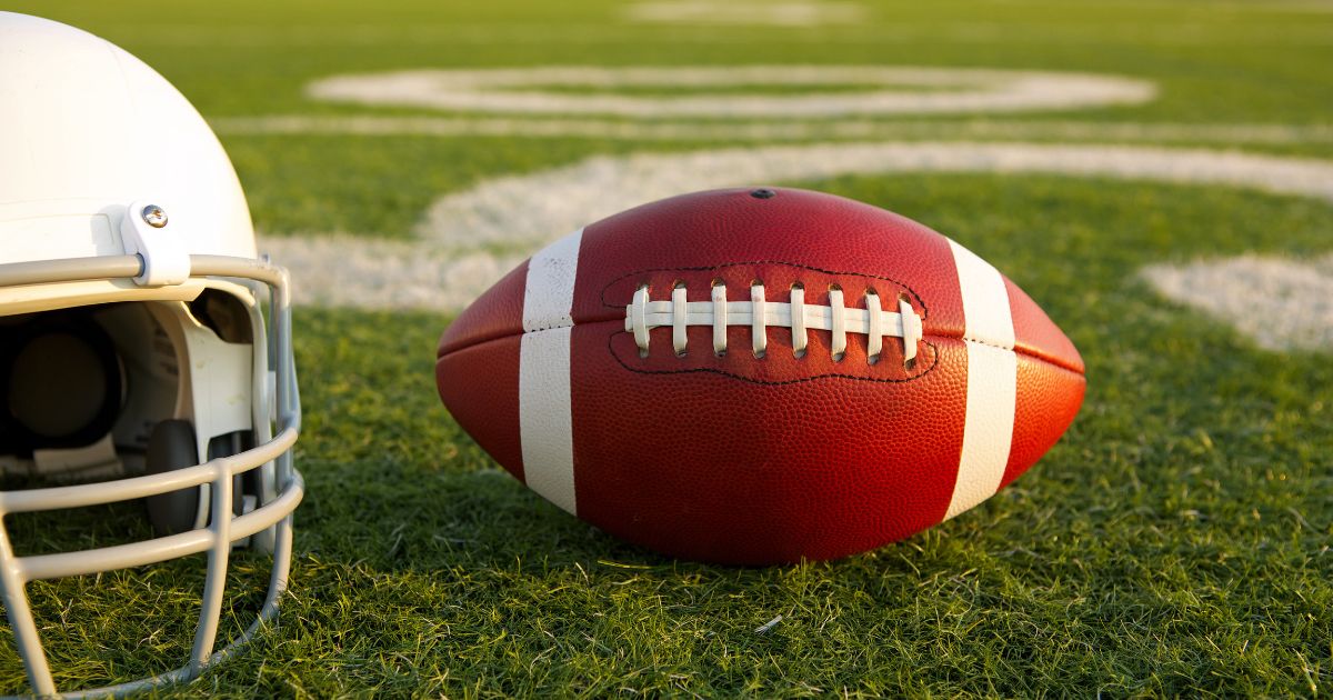 A football and helmet are seen in this stock image.