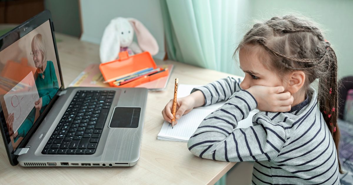 A girl participates in a virtual class in this stock image.