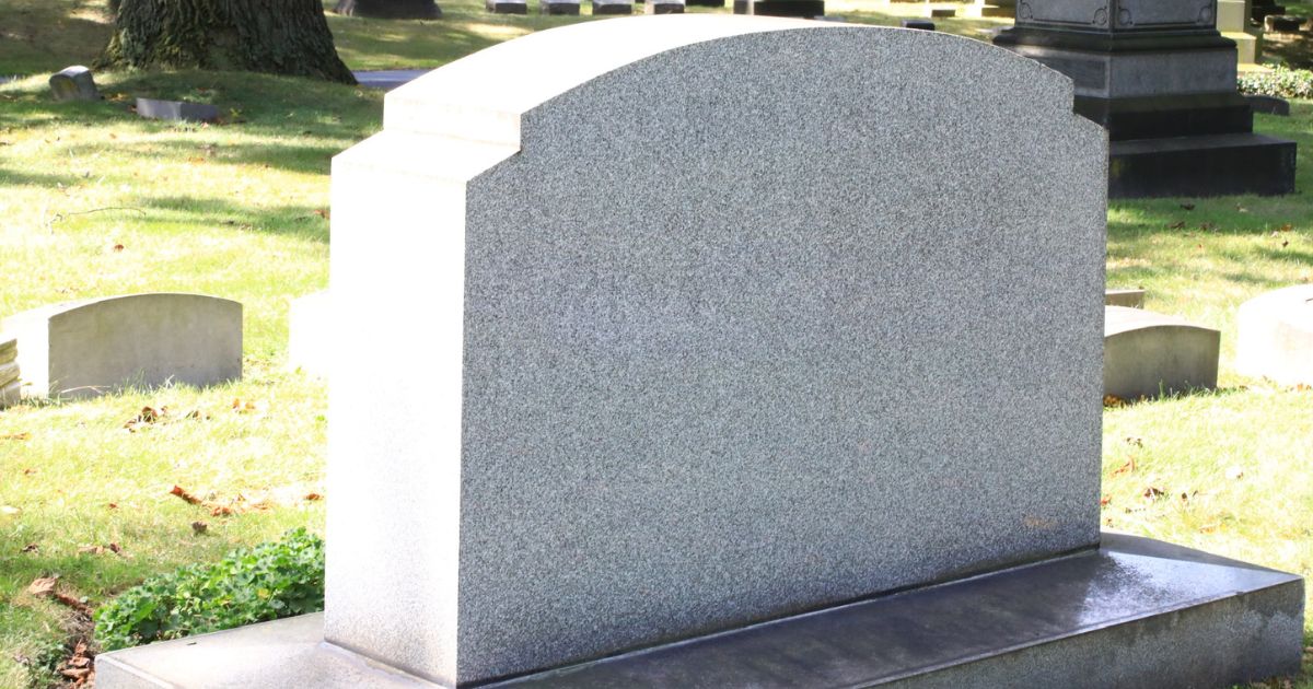 This stock photo pictures a gravestone in a cemetery.