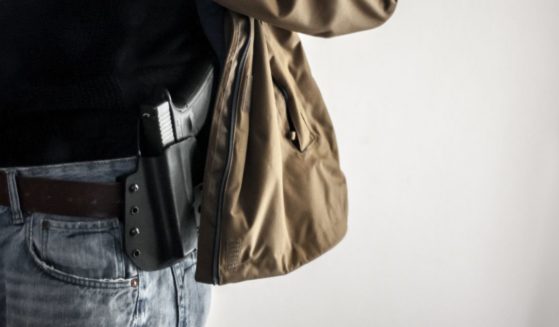 A man carrying a gun is seen in the above stock image.