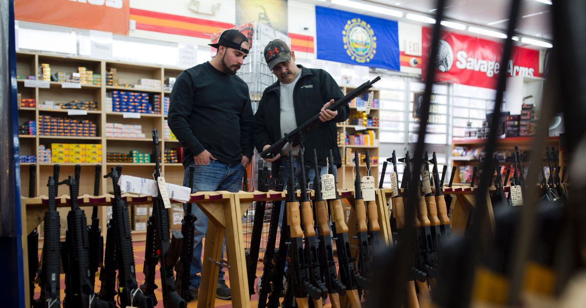 Customers look at a long gun at a gun shop on Nov. 5, 2016, in Merrimack, New Hampshire.