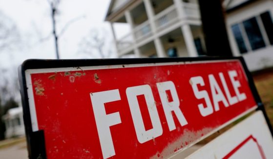 a for sale sign hangs in front of a home in Georgia