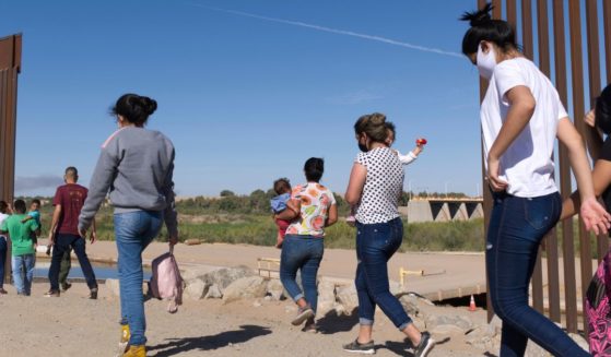 a group of illegal immigrants make their way around a gap in the U.S.-Mexico border in Yuma, Ariz