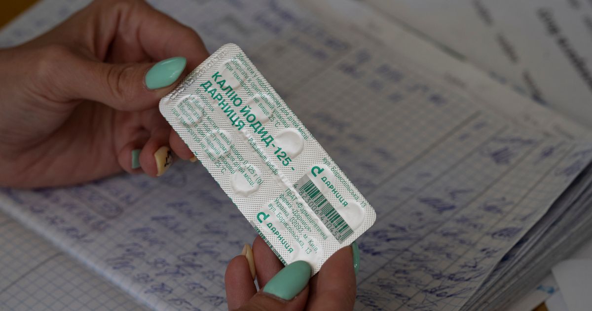 A woman shows a pack with iodine tablets before distributing them to residents at a local school in case of a radiation leak in Zaporizhzhia, Ukraine, on Sept. 2.