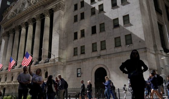 Visitors to the financial district walk past the New York Stock Exchange on Friday.