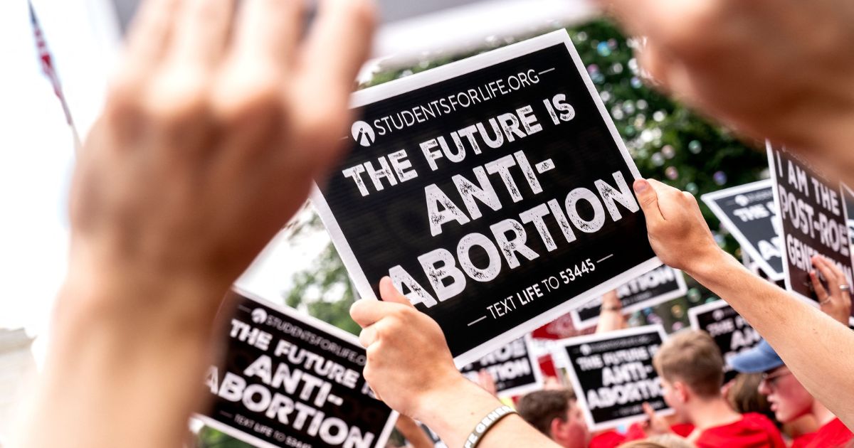 Pro-life activists hold signs outside the Supreme Court in Washington, D.C., on June 24.
