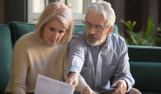 a serious gray-haired mature couple calculating bills