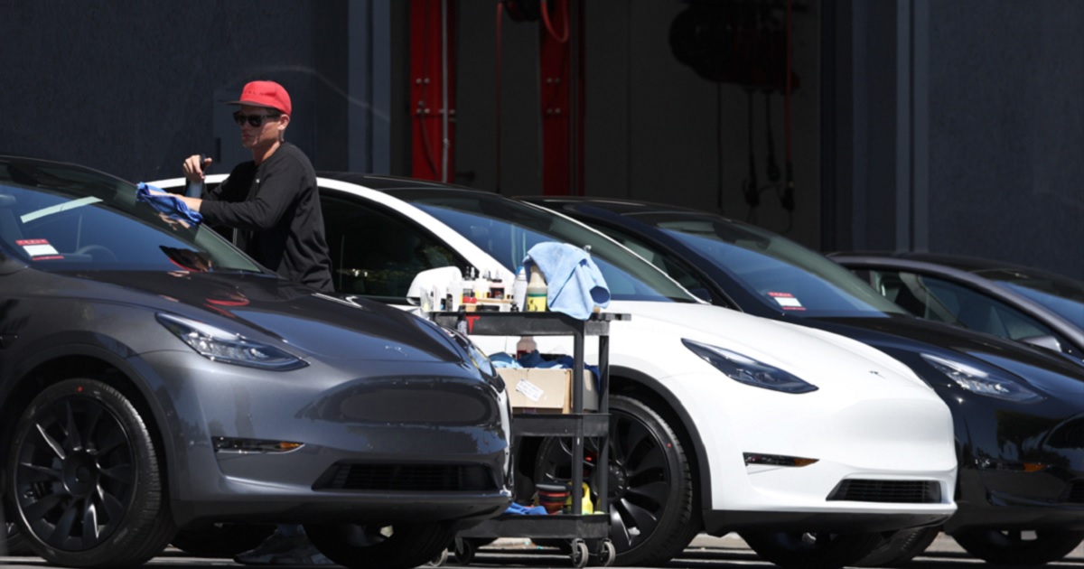 A worker cleans a brand new Tesla car at a Tesla showroom in Marin County, California, in June.