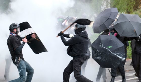 protester swings a baton