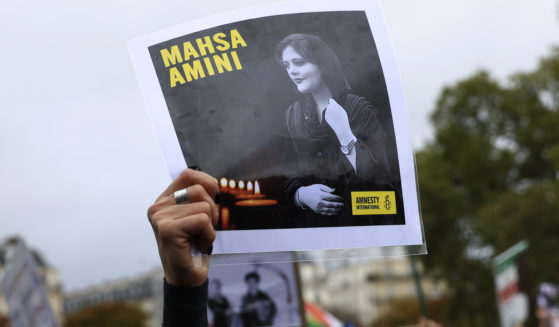 A protester shows a portrait of Mahsa Amini during a demonstration to support Iranian protesters standing up to their leadership over the death of a young woman in police custody on Sunday in Paris.