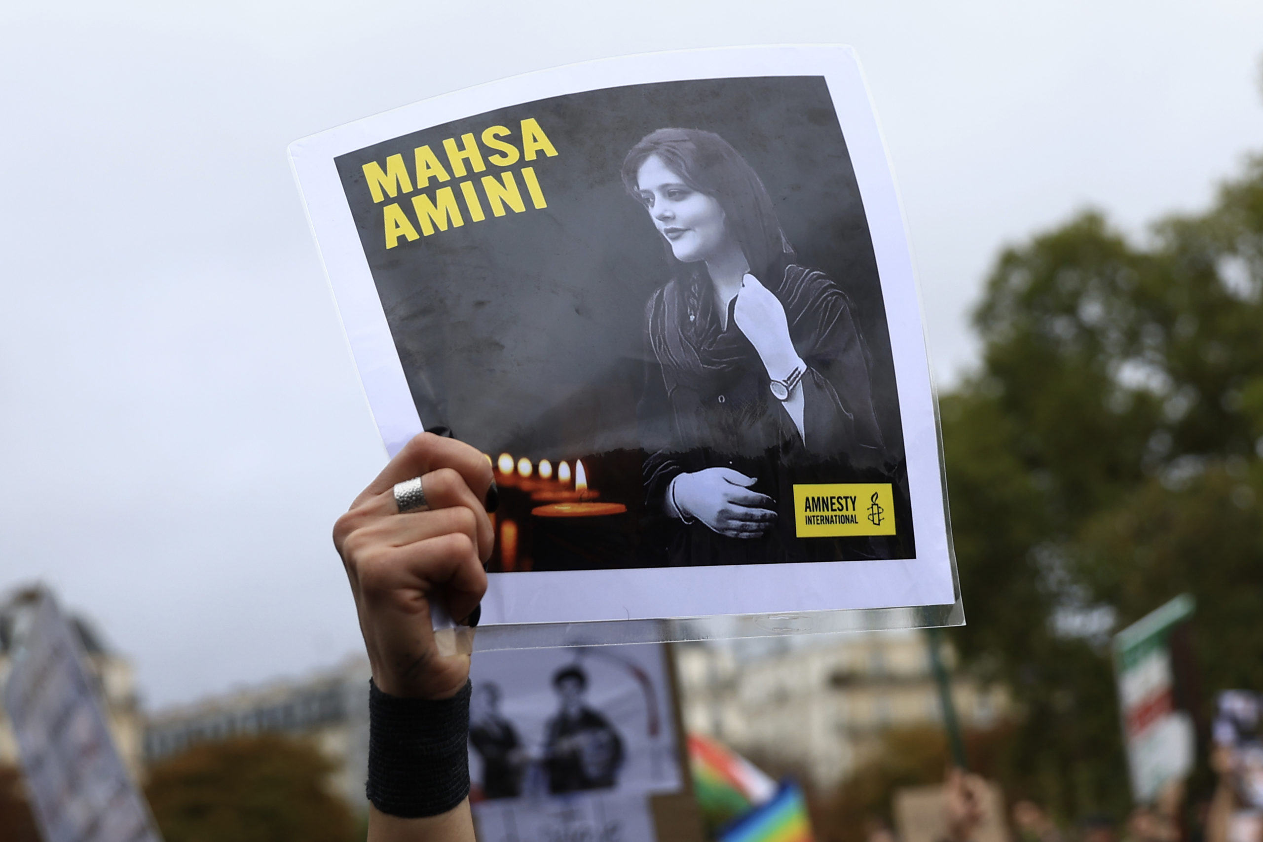 A protester shows a portrait of Mahsa Amini during a demonstration to support Iranian protesters standing up to their leadership over the death of a young woman in police custody on Sunday in Paris.