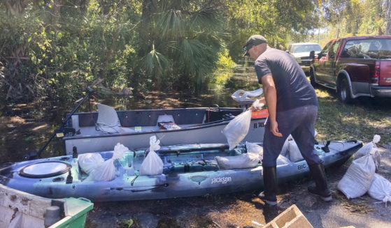 On Sunday, Gabriel Madling, a resident of Seminole County, Florida, loads sandbags into a kayak, so he can fortify his house from floodwaters left behind by Hurricane Ian.