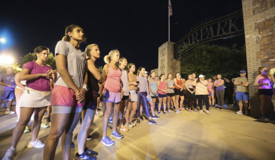 Members of the Tupelo Running Club and others gather for a moment of silence before their "Liza's Lights" run, in honor of Eliza Fletcher, on the morning of Sept. 9.