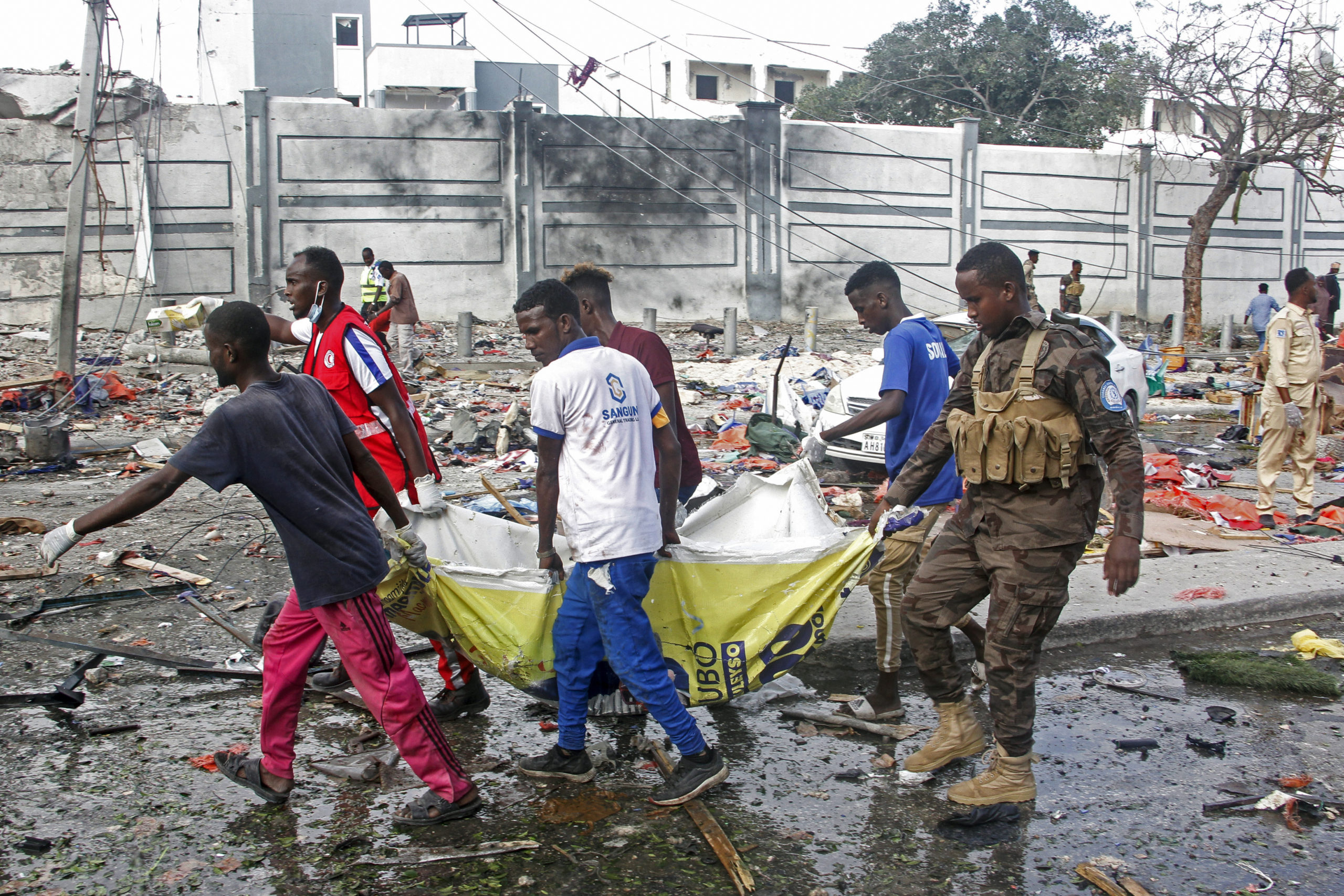 Rescuers remove a body from the scene of two car bomb attacks in Mogadishu, Somalia, Saturday. The bombs exploded Saturday at a busy junction in Somalia's capital near key government offices, leaving "scores of civilian casualties," police told state media.