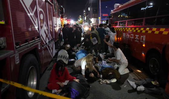 First responders and others attempt to help those who are injured after a crowd surge in Seoul, South Korea, on Saturday led to those attending the Halloween party to be crushed.