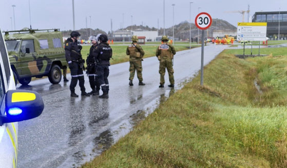 Police and personnel from the Home Guard stand guard outside the land plant of the Ormen Lange gas field after a person called in a bomb threat against the plant in Aukra, Norway, on Thursday.