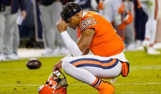 Chicago Bears quarterback Justin Fields kneeling on the field after falling to score