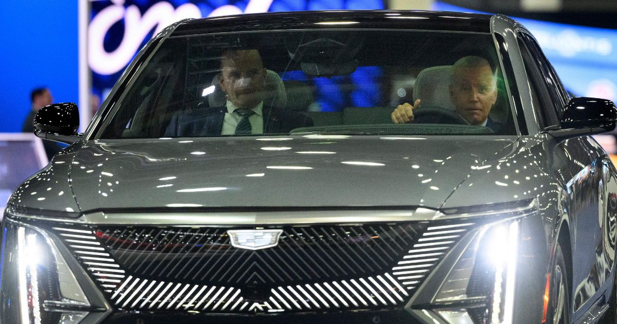 President Joe Biden drives a Cadillac LYRIQ electric vehicle as he tours the Detroit Auto Show on September 14.