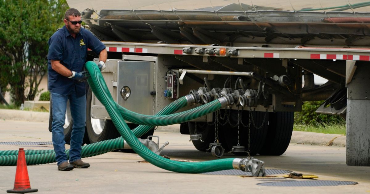 A gas tank driver adjusts his hose hookup to an underground tank in Jackson, Mississippi, on May 24.