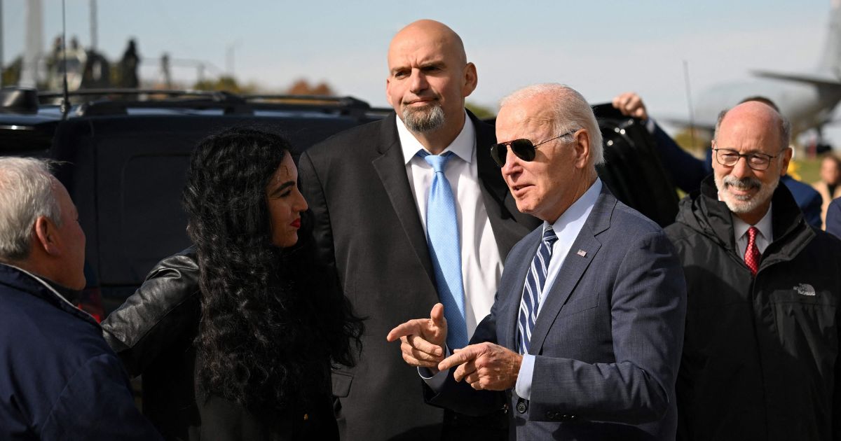Democratic senatorial candidate John Fetterman, center, stands next to his wife, Gisele, and looks on while President Joe Biden speaks with Pennsylvania officials after arriving at Pittsburgh International Airport on Thursday.