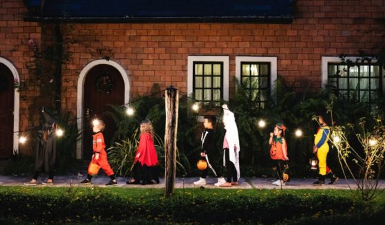 Children in Halloween costumes go trick-or-treating.