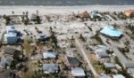 Damaged homes and debris in Fort Myers Beach are shown in the wake of Hurricane Ian Thursday. Florida officials are warning residents to be on the alert for the next wave of danger, this time from predatory insurance scam artists.