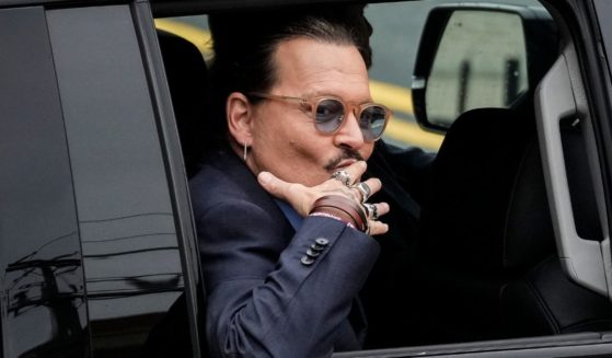 Johnny Depp blows a kiss to fans as he drives away from the Fairfax County Courthouse in Fairfax, Virginia, on May 27.