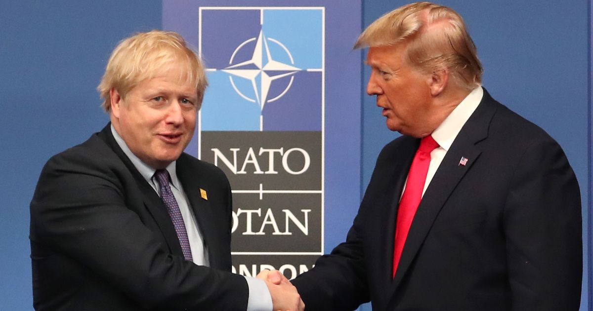 Then-British Prime Minister Boris Johnson shakes hands with then-President Donald Trump in a file photo taken during the annual from December 2019.