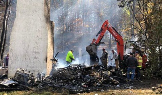 Firefighters in Edmonton, Kentucky, search the rubble of the home where former appeals judge and gubernatorial candidate Thomas Emberton died early Thursday.