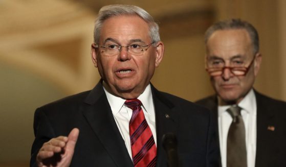Democratic Sen. Robert Menendez of New Jersey talks to reporters while then-Senate Minority Leader Charles Schumer looks on following the weekly Democratic policy luncheon at the U.S. Capitol in Washington on Feb. 25, 2020.