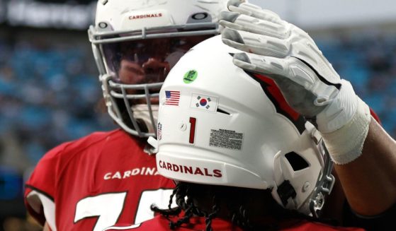 A South Korean flag is seen on the helmet of Arizona quarterback Kyler Murray as he is congratulated by a teammate after a touchdown in the fourth quarter of the Cardinals' game against the Carolina Panthers at Bank of America Stadium on Sunday.