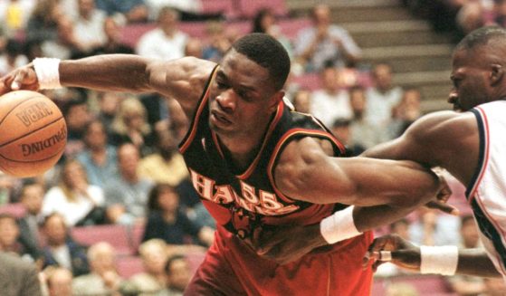 Dikembe Mutombo, left, is fouled by the New Jersey Nets' Michael Cage as he drives towards the basket in a file photo from March 1998.