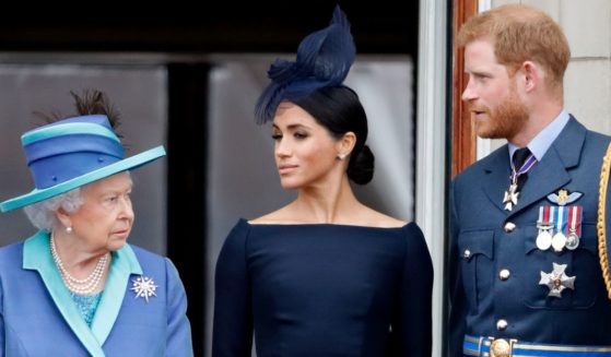 Queen Elizabeth II, Meghan, Duchess of Sussex and Prince Harry, Duke of Sussex watch a celebration marking the centenary of the Royal Air Force from the balcony of Buckingham Palace in July of 2018 in London.