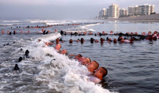 Navy SEAL candidates participate in "surf immersion" during Basic Underwater Demolition/SEAL (BUD/S) training at the Naval Special Warfare Center in Coronado, Calif.,in a file photo from May 2020. A new report says the Naval Special Warfare Command has reprimanded three officers in connection with the February 2022 death of SEAL candidate Kyle Mullen, who collapsed and died of acute pneumonia just hours after completing the grueling Hell Week test.