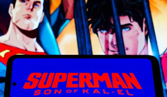 The logo for "Superman: Son of Kal-El" is displayed on a cellphone in this stock image.