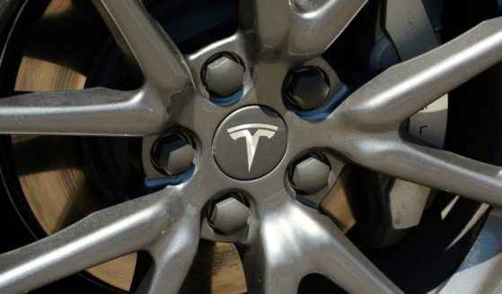 A wheel rim with a Tesla logo is seen on an electric car parked at a charging station in Crater Lake National Park in Oregon.
