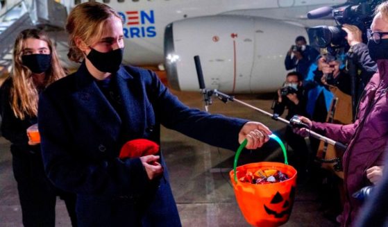 Then-Democratic presidential candidate Joe Biden's granddaughters Natalie Biden, left, and Maisy Biden, right, pass out Halloween candy to members of the media at New Castle Airport in New Castle, Delaware, on Oct. 21, 2020.