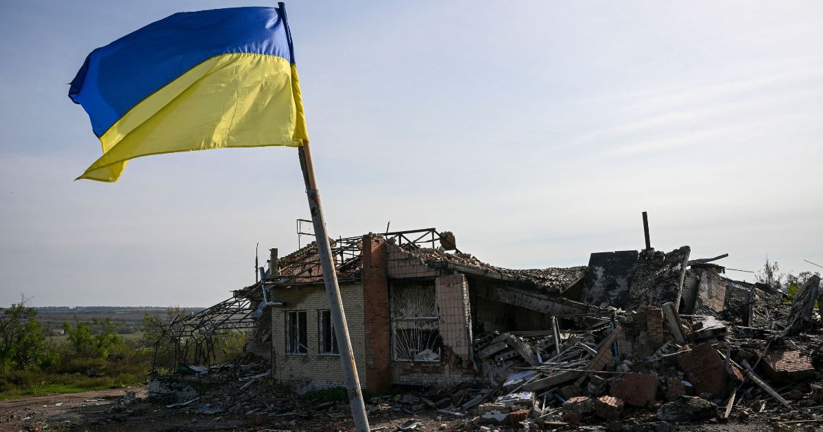 A Ukrainian flag is displayed in front of a destroyed house near Izyum, eastern Ukraine, on Oct. 1.