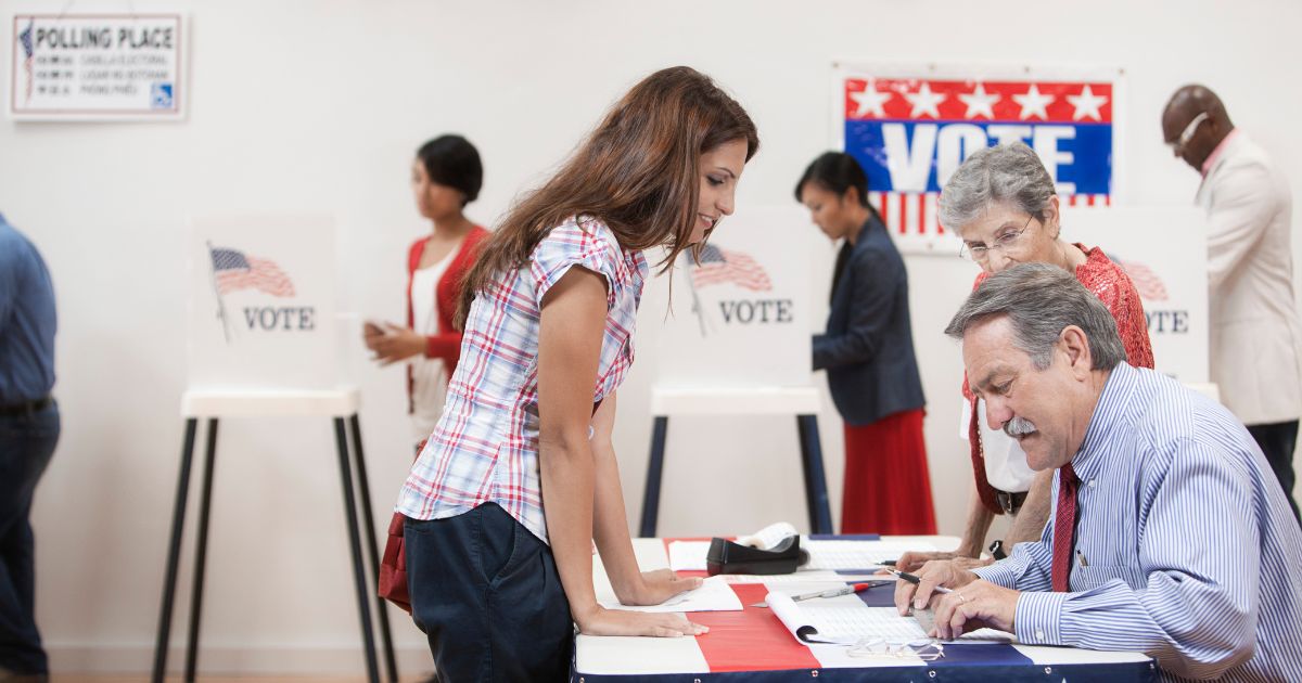 A photo illustration depicts a voter checking in with a poll worker before voting.