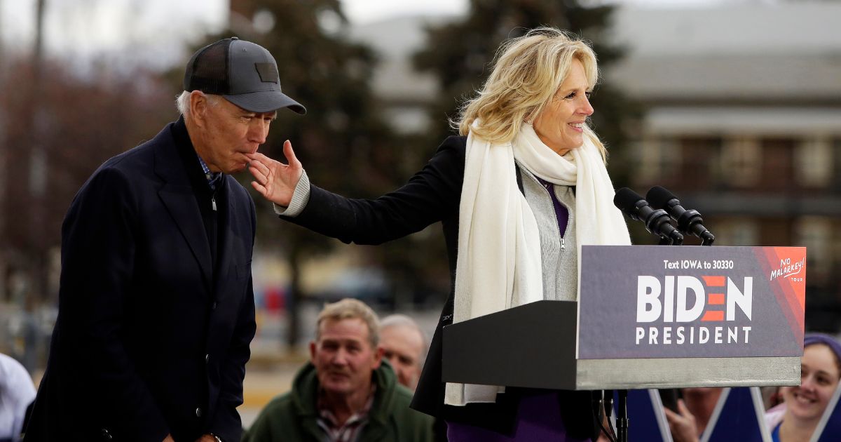 Now-President Joe Biden bites the finger of his wife, Jill, as she introduces him during a campaign in November 2019 in Council Bluffs, Iowa, during the campaign for the Democratic presidential nomination.
